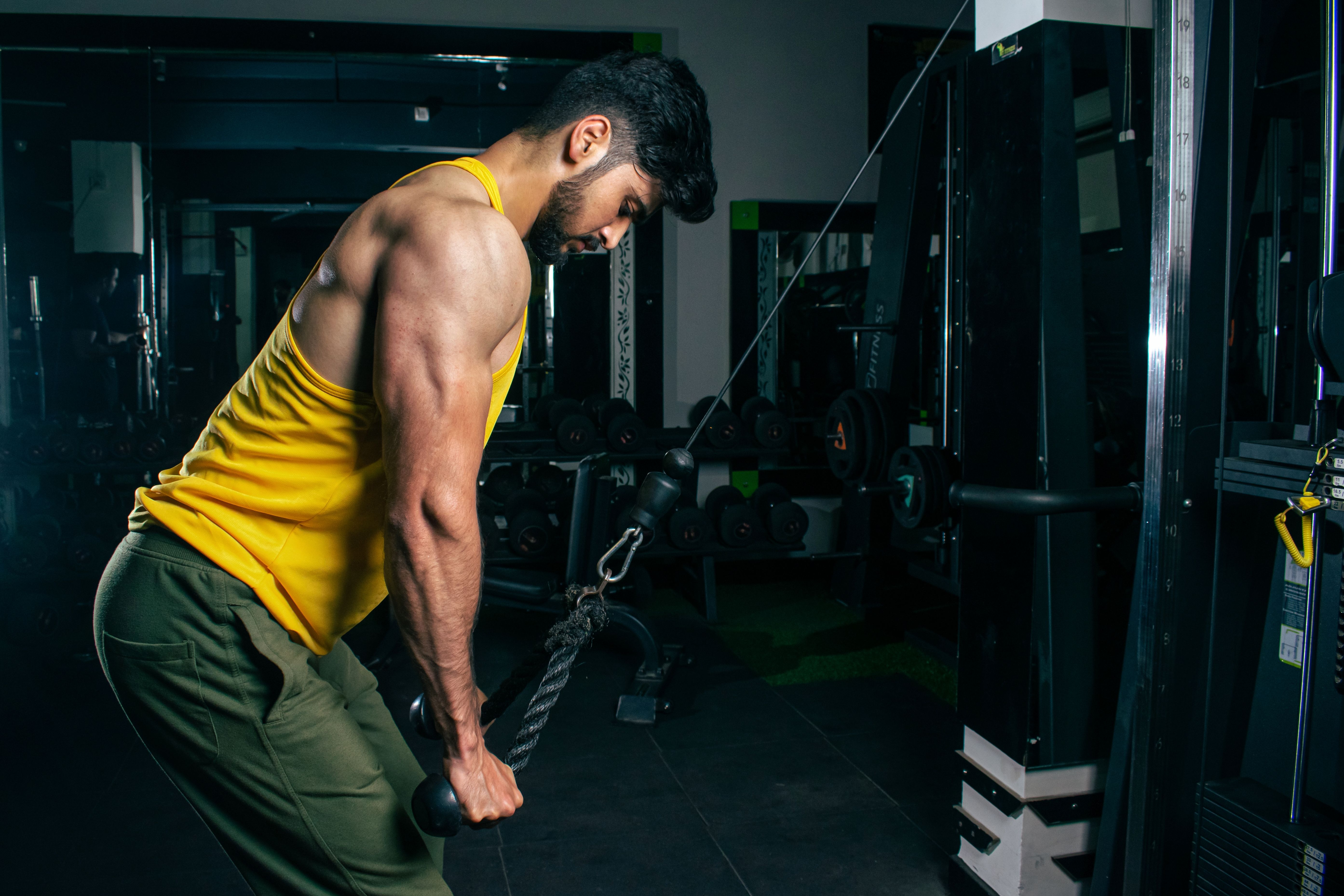 Man performing a standing dumbbell curl in a bright room