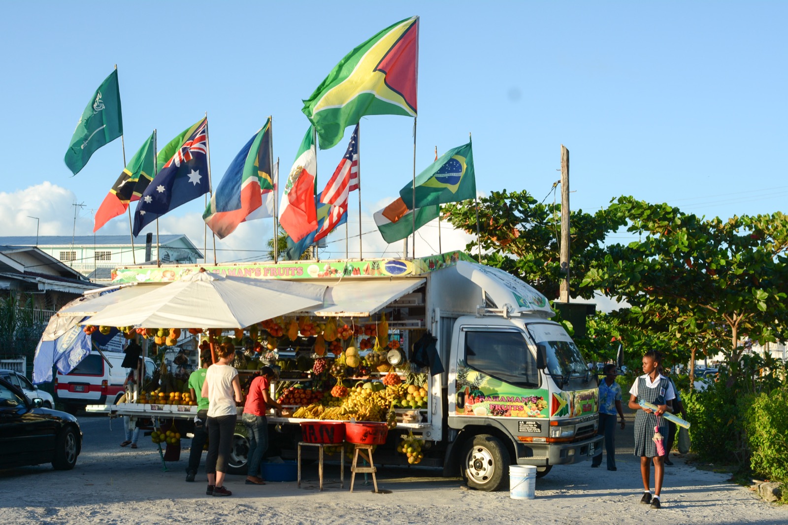 A fruit vendor's truck flying the Guyana flag, piled high with produce