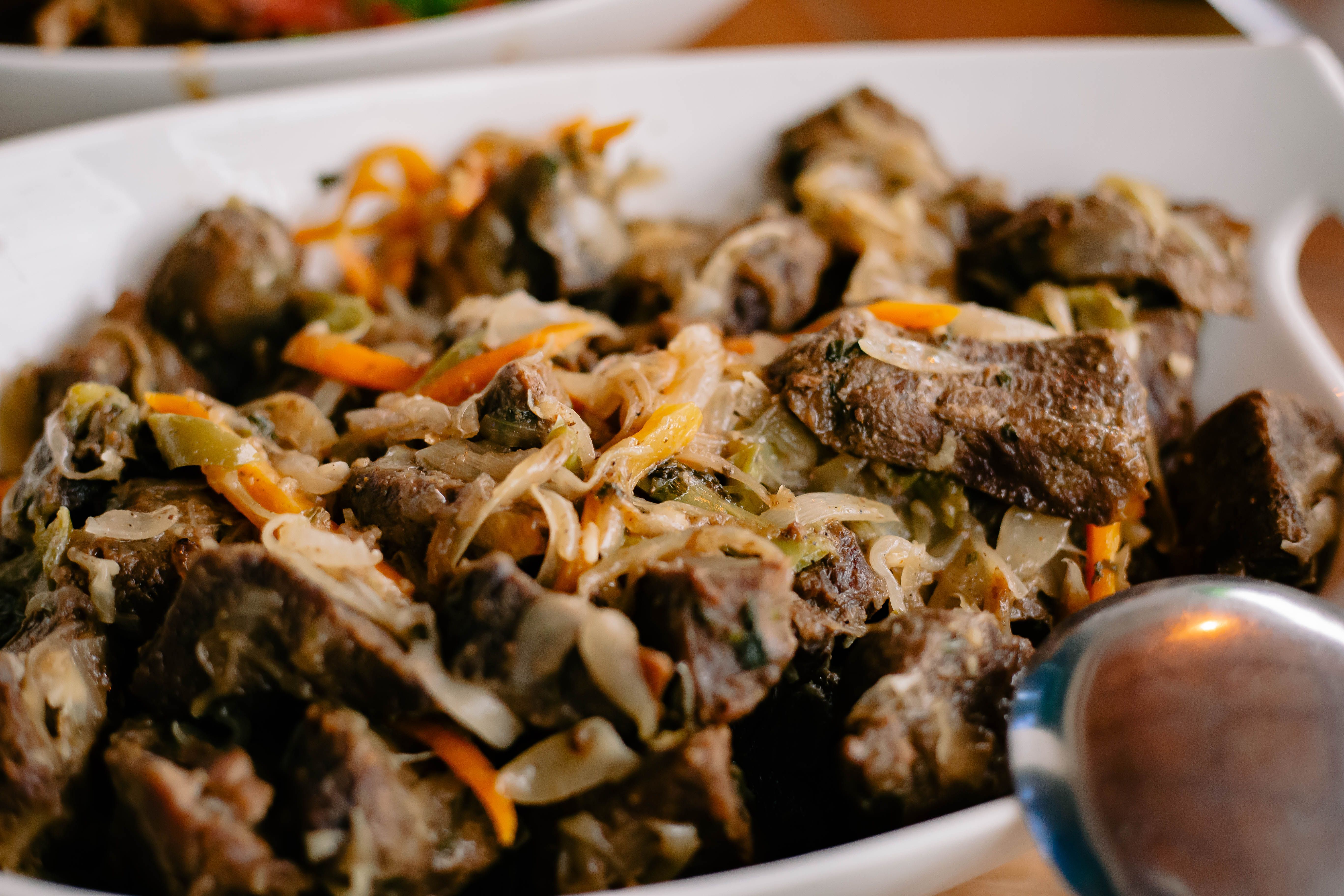 Stewed beef with sautéed cabbage and shredded carrot in a serving dish