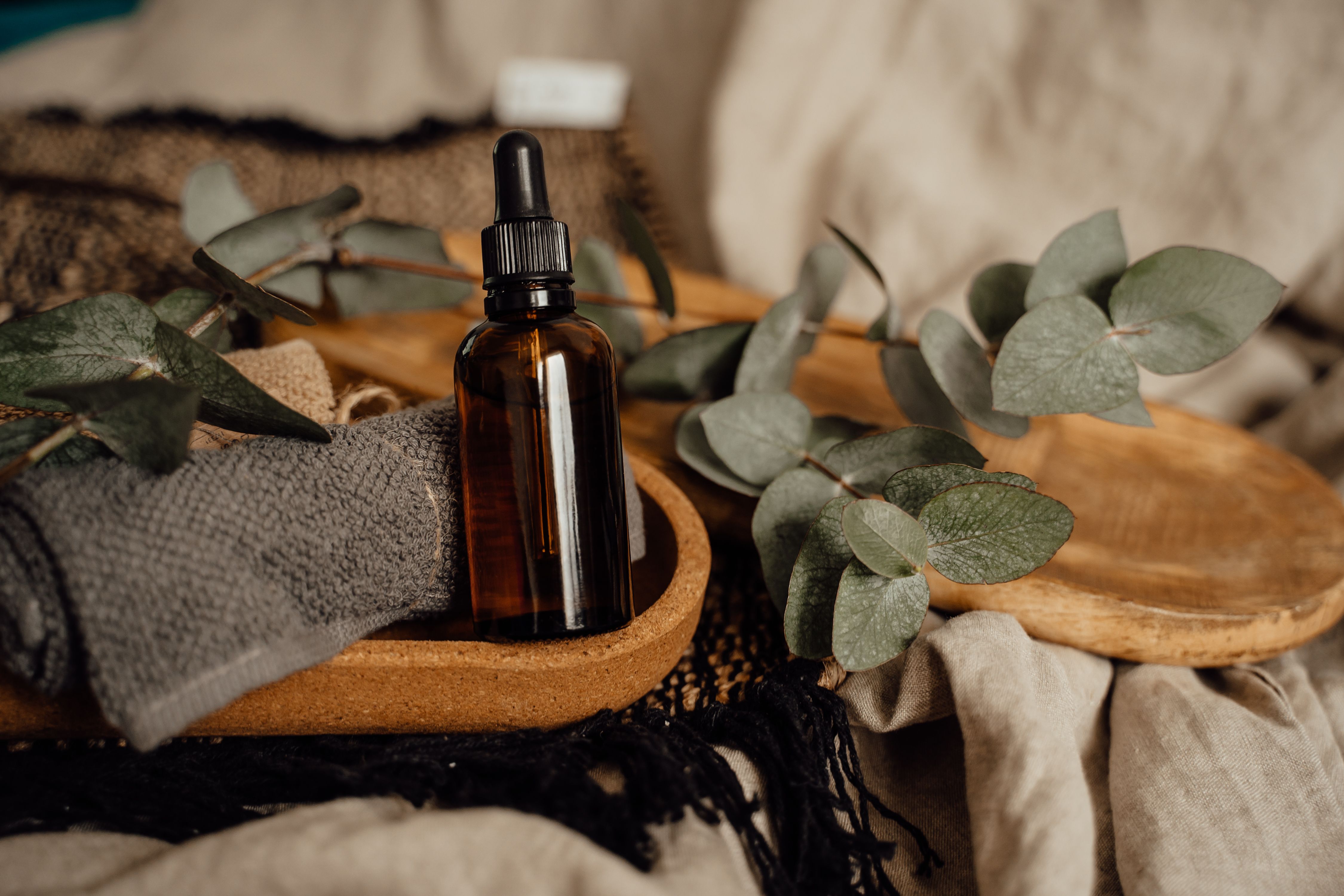 Minimalist skincare product lineup — pump bottle, dropper and cream jar on a white surface