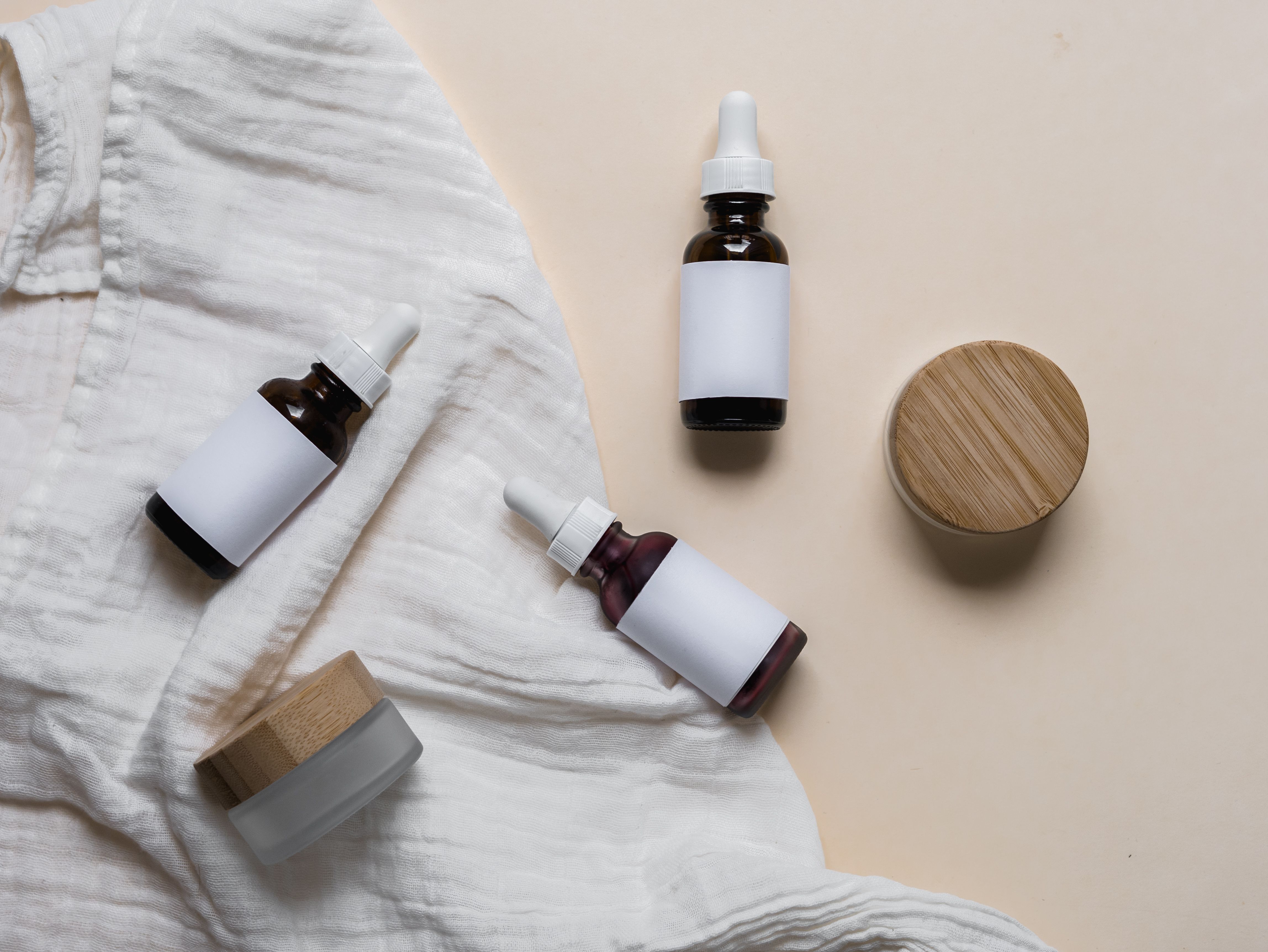 Amber dropper serum bottles laid flat on fabric