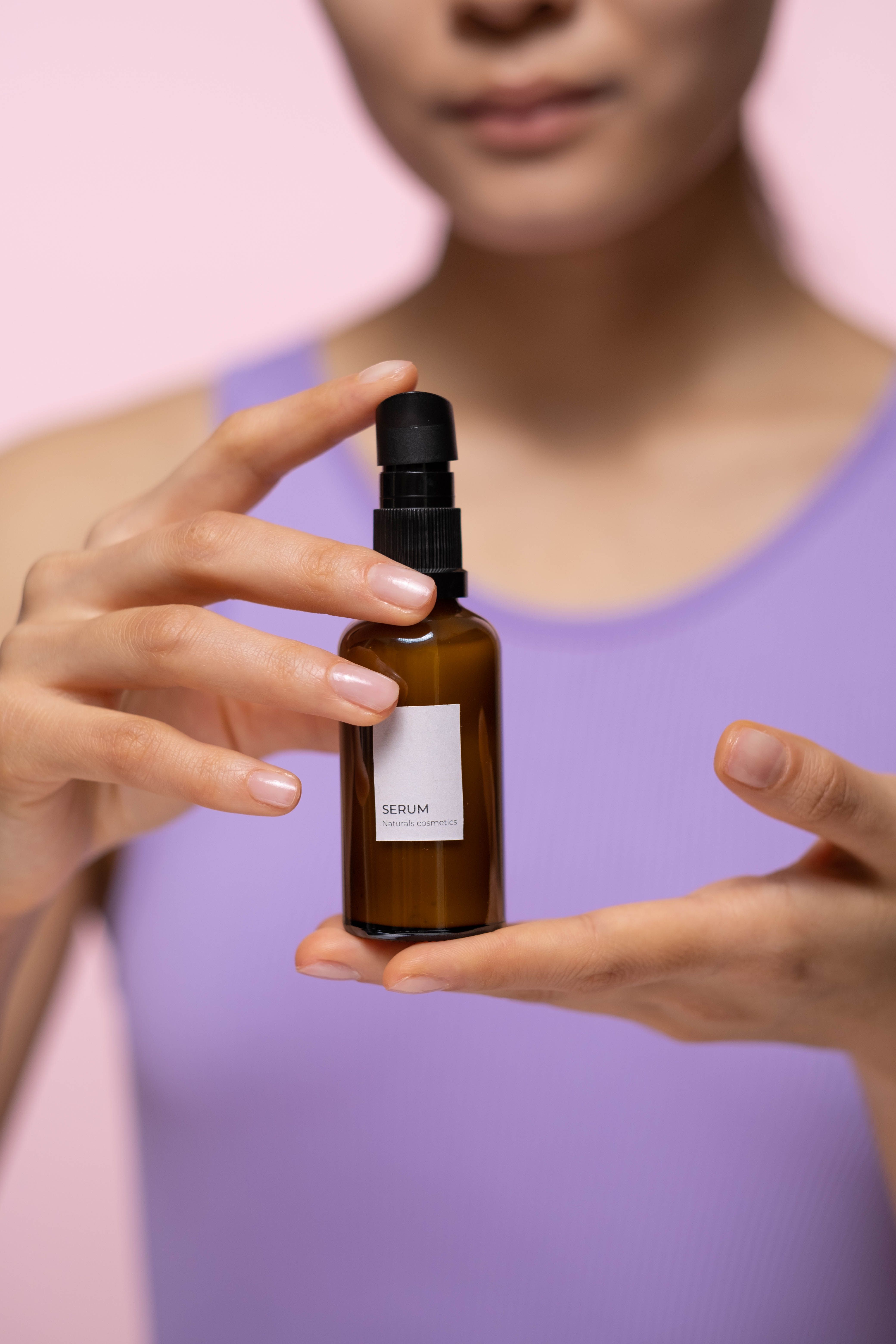 Woman holding an amber serum bottle
