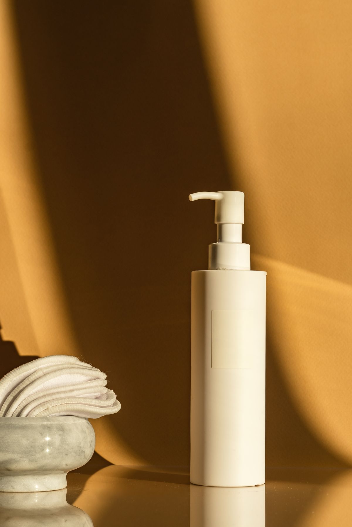 Skincare products styled with cotton pads on a warm background