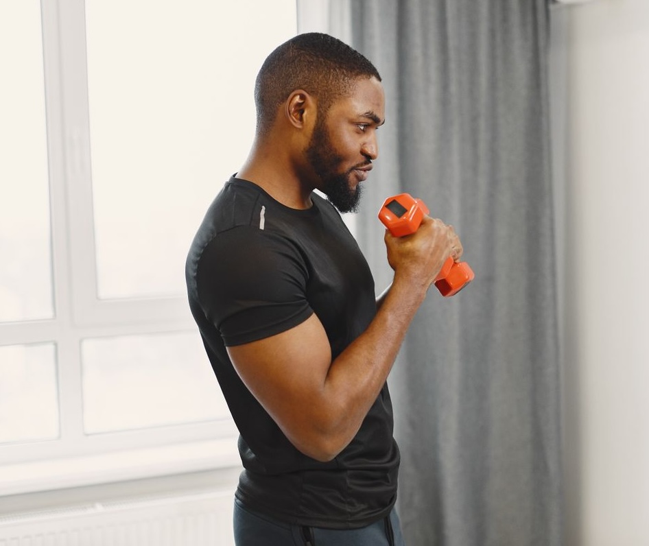 Trainer coaching a client through a core exercise on gym equipment